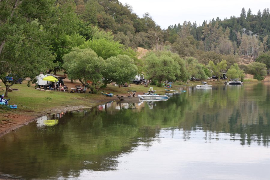 Waterfront campsites with boats along the Rollins Lake shoreline