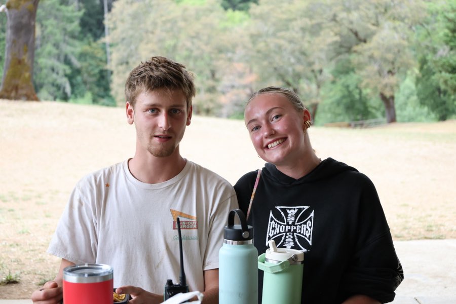 Two Greenhorn summer staff members at a picnic table with a two-way radio