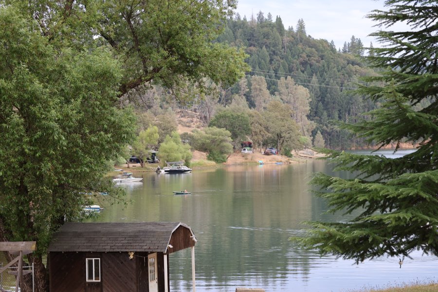 A view of the lake past the old boathouse with a kayaker on the water